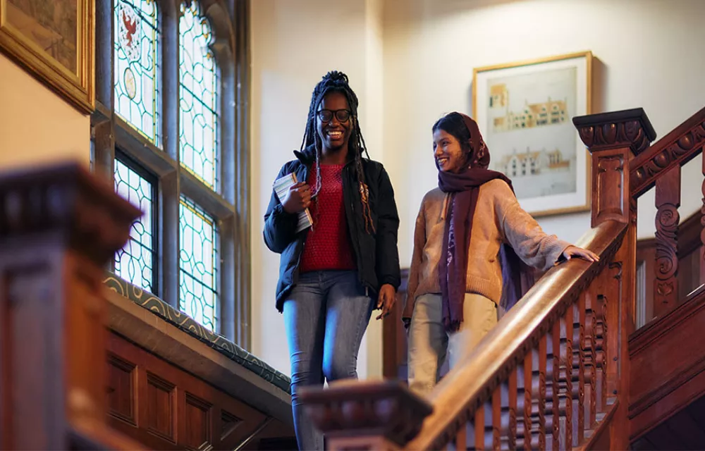 Two students walking down a staircase