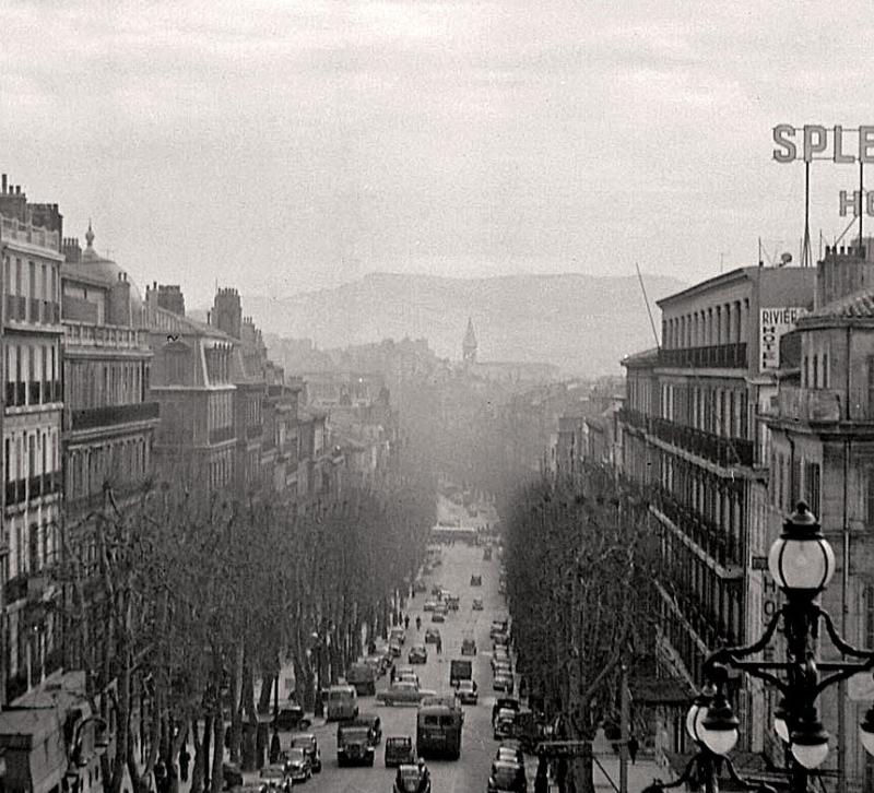 Historical view down a street with the The Hotel Splendide to the right