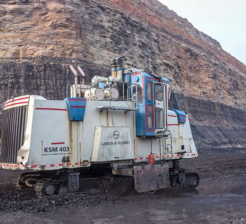 Surface miner against backdrop of rock