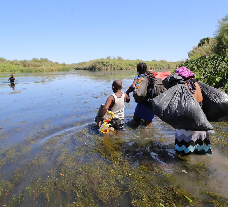 A family starts to cross the Río Grande on foot carrying their possessions