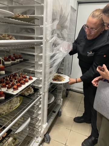 Kitchen staff show off plated food on trolleys