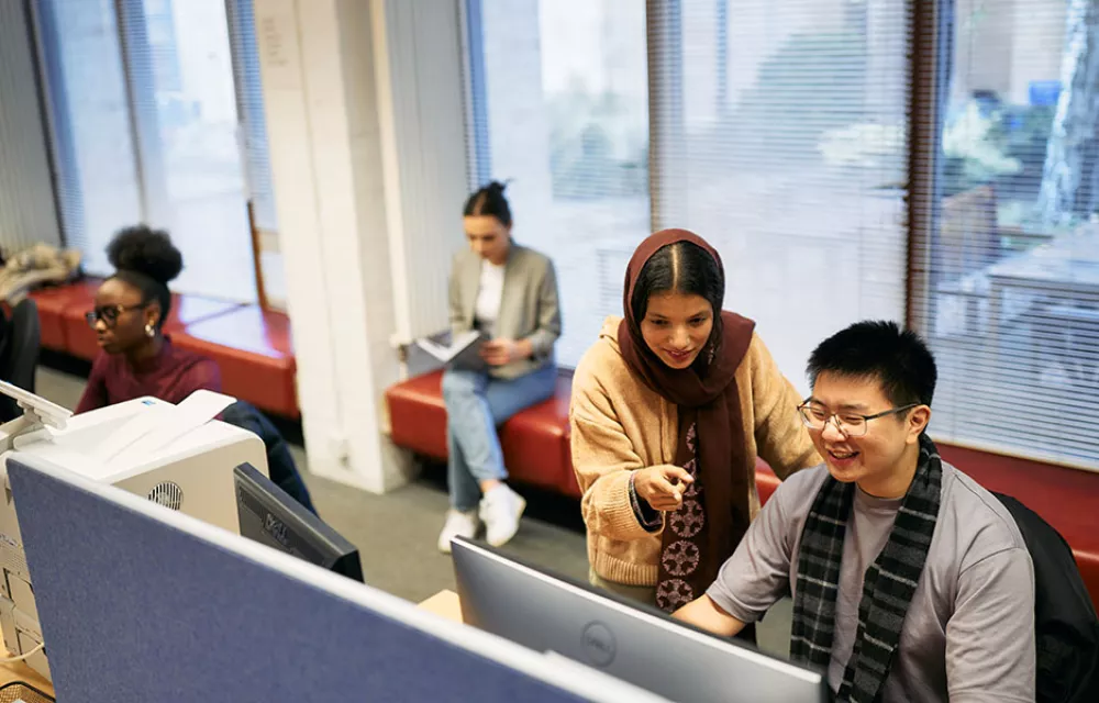 Four students working in computer area