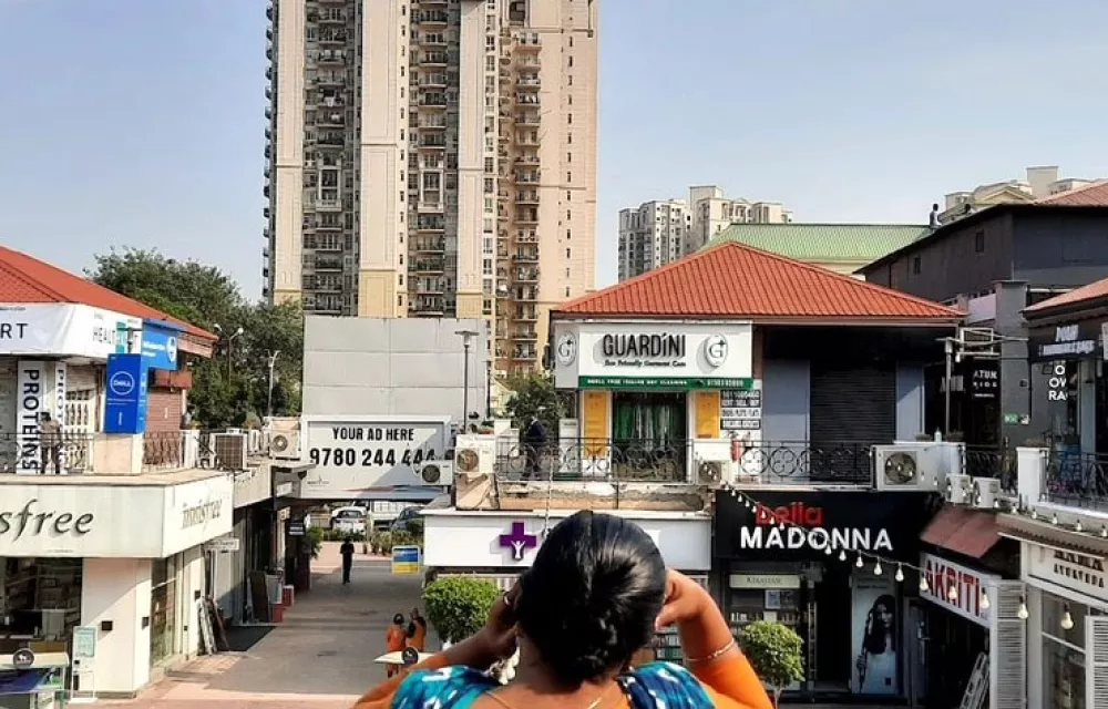 A women seen from behind looking out over a shopping area in India