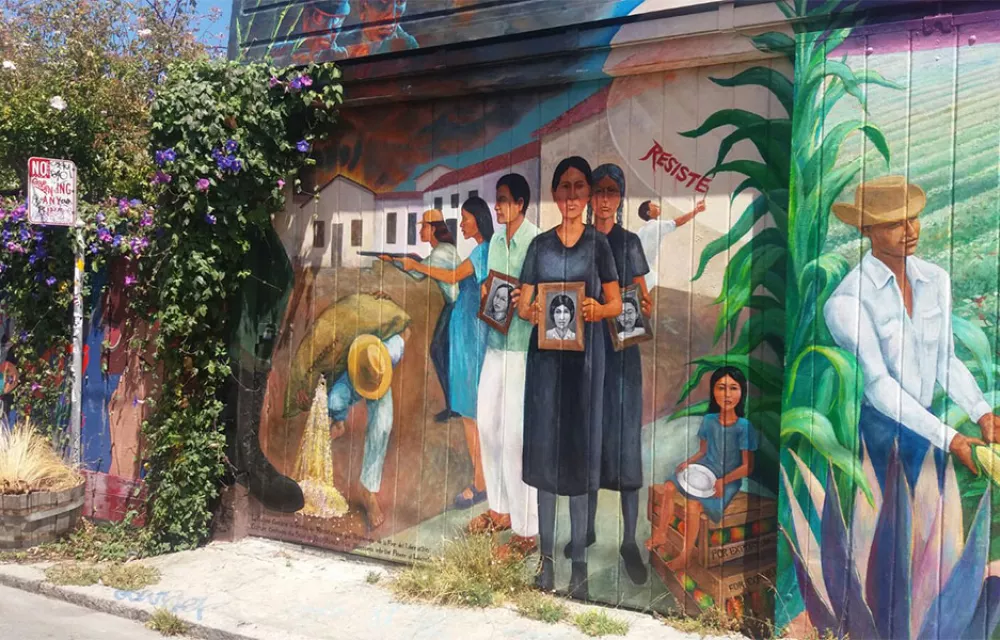 A colourful mural by a bustop showing women protesting