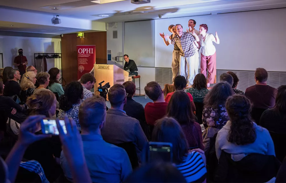 Actors grouped on a stage in front of an audience