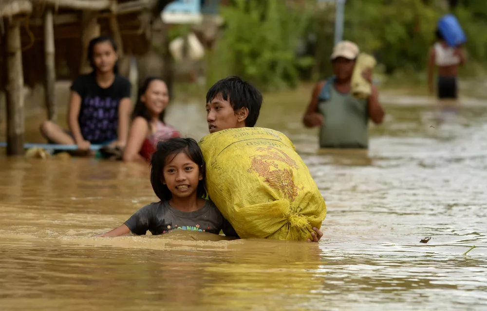 A girl wades on the flooded street of Barangay Camunatan, Isabela, north of Manila