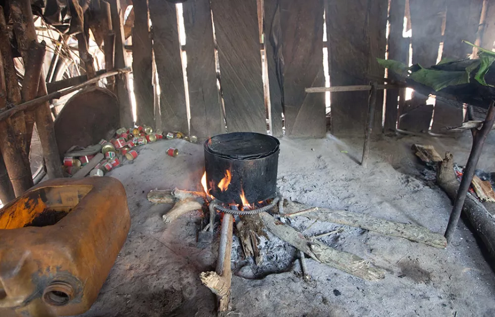 A cooking pot over an open fire in a dwelling