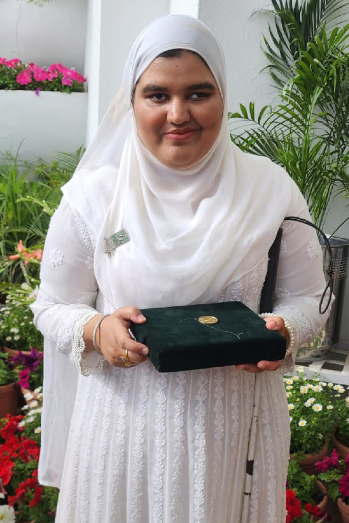 Khansa Maria holding the box containing her medal