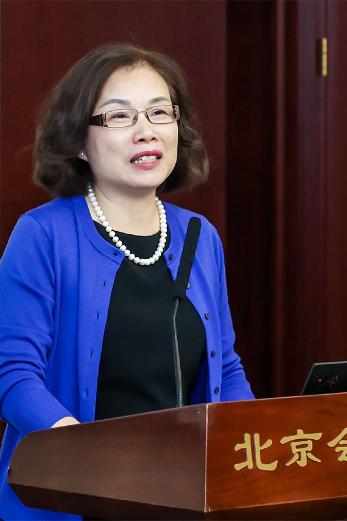 Professor Xiaolan Fu speaking at a podium