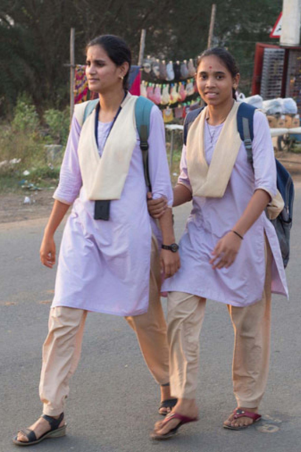 Two young women walking on a street in India