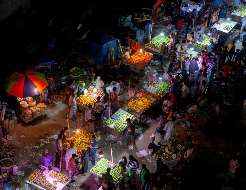 Brightly coloured market stalls lit up at night