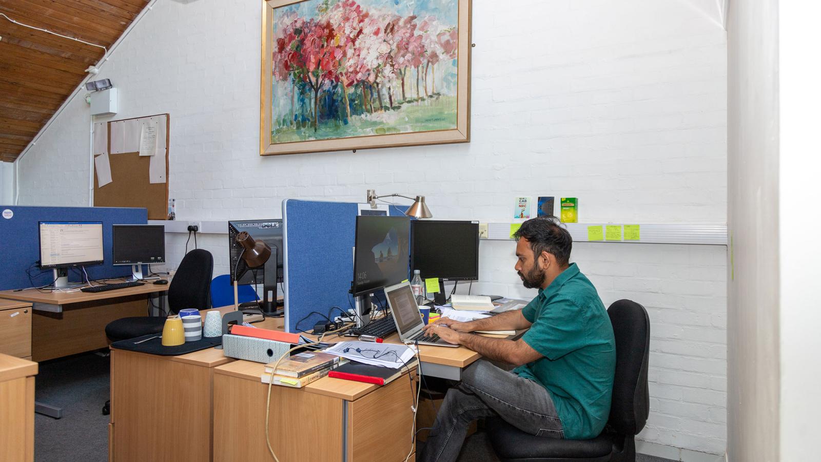 Student seated at desk in DPhil loft area