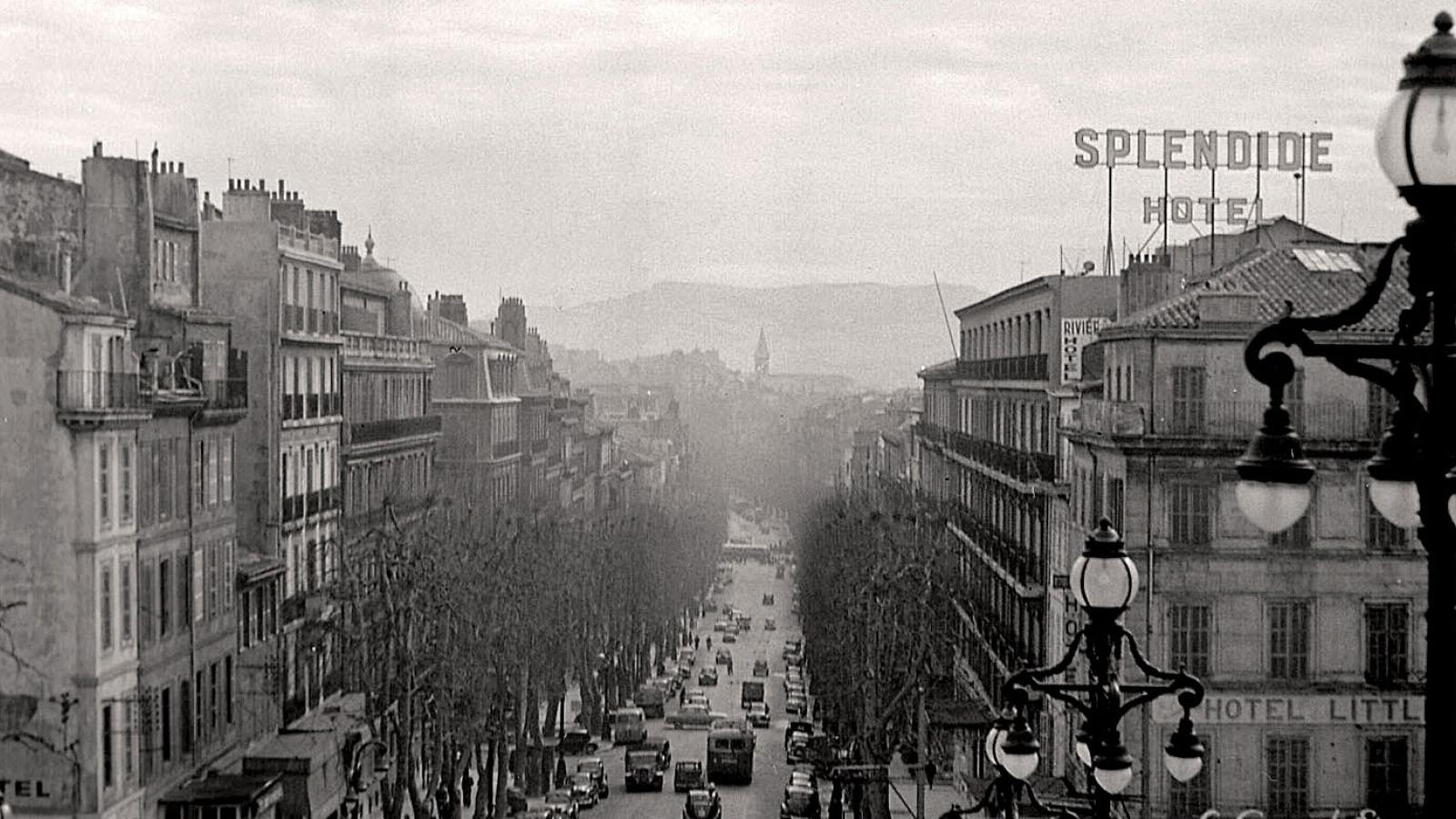 Historical view down a street with the The Hotel Splendide to the right