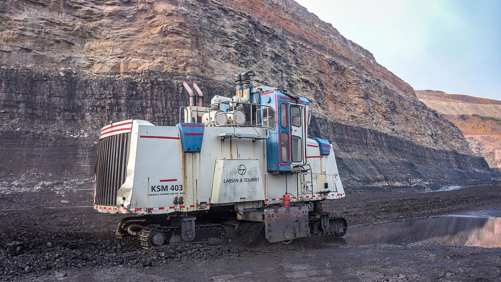 Surface miner against backdrop of rock